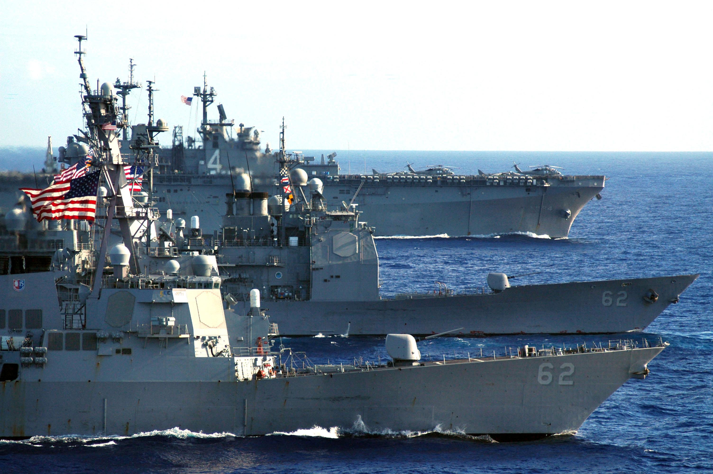 3 US Navy Battleships in a row with USA flags hanging